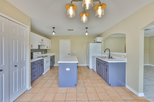 11438 Ivy Flower Loop, Riverview, FL 33578 - kitchen featuring white appliances, arched walkways, a center island, under cabinet range hood, and light countertops