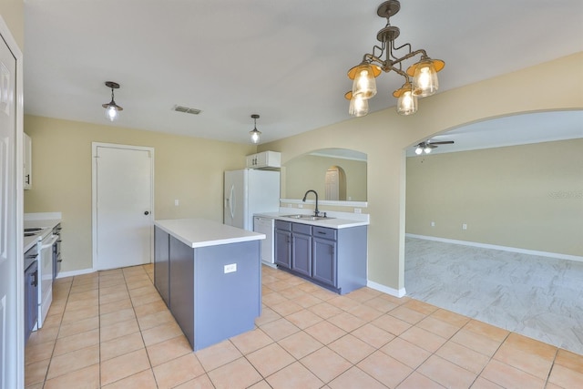 11438 Ivy Flower Loop, Riverview, FL 33578 - kitchen with arched walkways, white appliances, light countertops, ceiling fan, and a chandelier