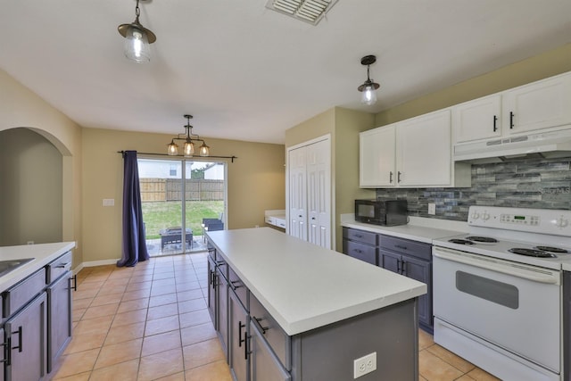 11438 Ivy Flower Loop, Riverview, FL 33578 - kitchen with white electric stove, under cabinet range hood, backsplash, and decorative light fixtures
