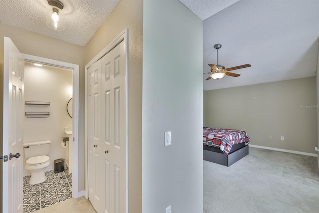 11438 Ivy Flower Loop, Riverview, FL 33578 - bedroom with a textured ceiling, ensuite bathroom, a closet, and carpet flooring