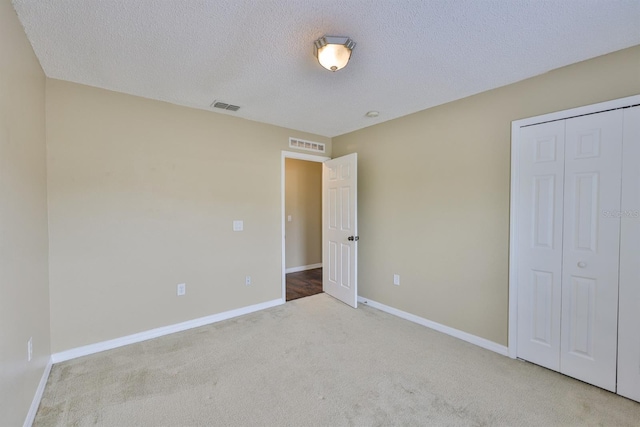 11438 Ivy Flower Loop, Riverview, FL 33578 - unfurnished bedroom featuring carpet floors, a textured ceiling, and a closet