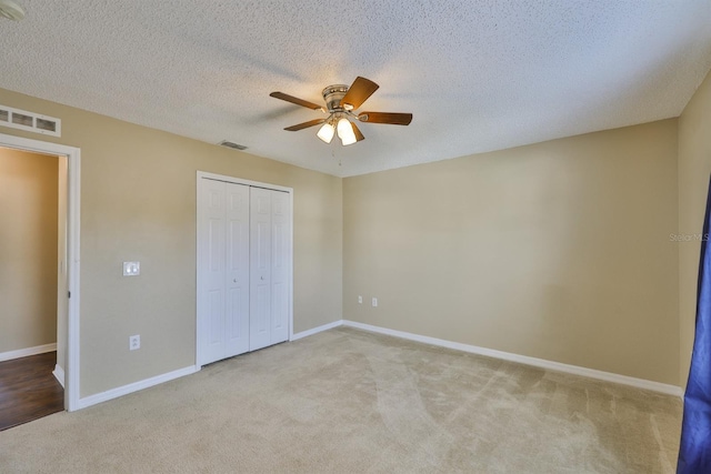 11438 Ivy Flower Loop, Riverview, FL 33578 - unfurnished bedroom featuring carpet, a closet, ceiling fan, and a textured ceiling
