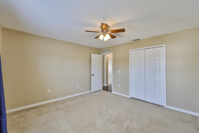 11438 Ivy Flower Loop, Riverview, FL 33578 - unfurnished bedroom featuring carpet flooring, a closet, a ceiling fan, and a textured ceiling
