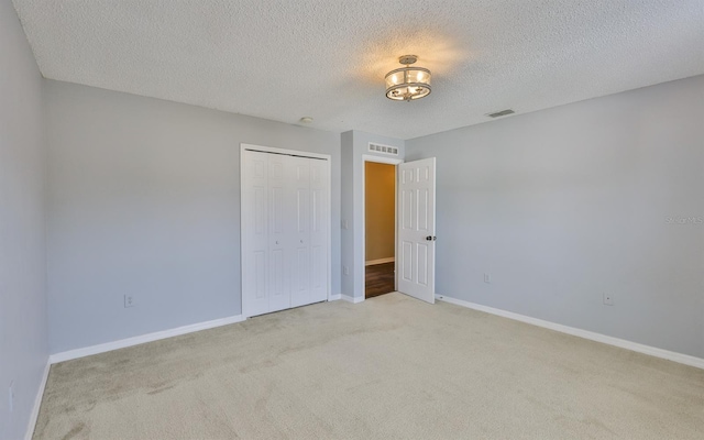11438 Ivy Flower Loop, Riverview, FL 33578 - unfurnished bedroom featuring light colored carpet, a textured ceiling, and a closet