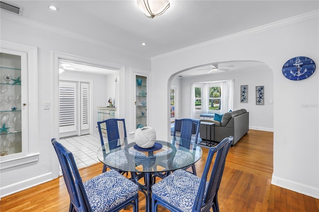 555 21st Ave NE, Saint Petersburg, FL 33704 - dining room with arched walkways, crown molding, wood finished floors, a ceiling fan, and recessed lighting