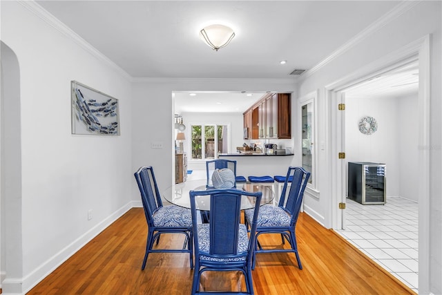555 21st Ave NE, Saint Petersburg, FL 33704 - dining room with beverage cooler, arched walkways, wood finished floors, ornamental molding, and recessed lighting