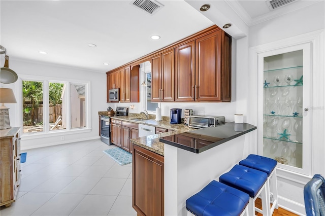 555 21st Ave NE, Saint Petersburg, FL 33704 - kitchen with appliances with stainless steel finishes, a kitchen breakfast bar, crown molding, light stone countertops, and recessed lighting