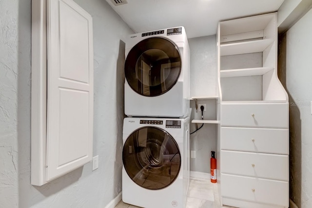 555 21st Ave NE, Saint Petersburg, FL 33704 - laundry area featuring stacked washer and clothes dryer and baseboards