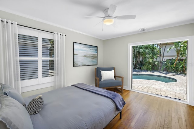 555 21st Ave NE, Saint Petersburg, FL 33704 - bedroom with wood finished floors, ornamental molding, ceiling fan, and access to outside