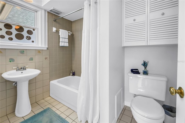 555 21st Ave NE, Saint Petersburg, FL 33704 - full bath with tile patterned floors, shower / tub combo, and tile walls