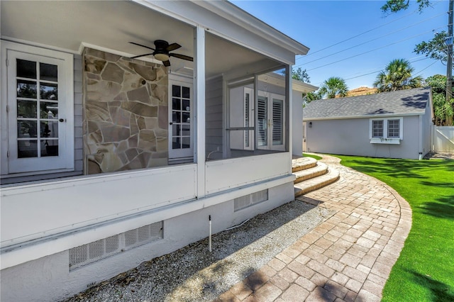 555 21st Ave NE, Saint Petersburg, FL 33704 - view of property exterior with ceiling fan, a sunroom, stone siding, and a lawn