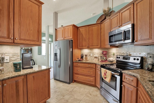 10597 Alvarado Ct, Seminole, FL 33772 - kitchen with appliances with stainless steel finishes, brown cabinets, tasteful backsplash, light stone countertops, and light tile patterned floors