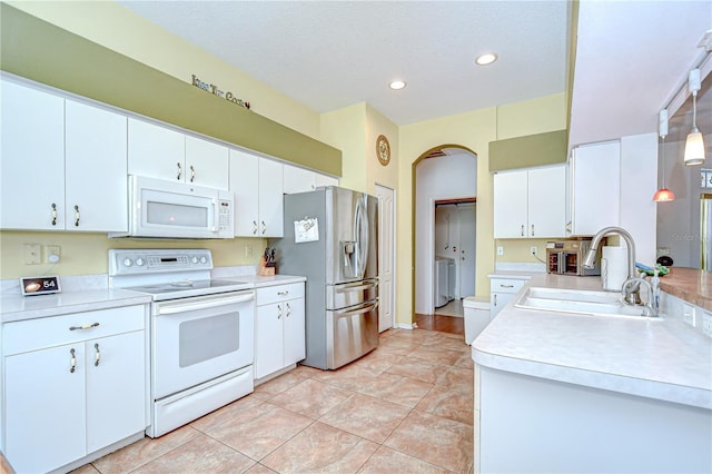 2226 N Creek Ct, Sun City Center, FL 33573 - kitchen with white appliances, arched walkways, light countertops, recessed lighting, and white cabinetry