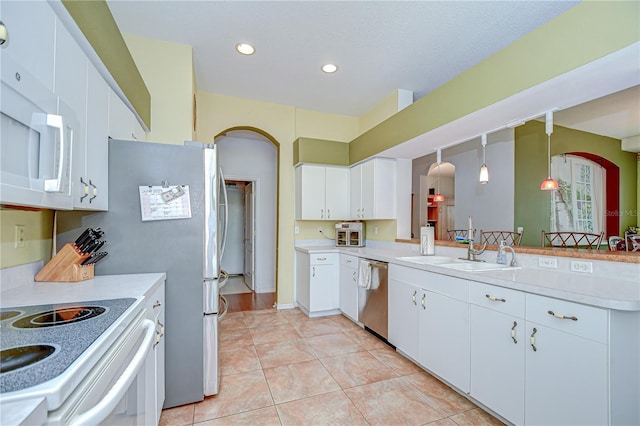 2226 N Creek Ct, Sun City Center, FL 33573 - kitchen featuring arched walkways, white appliances, light tile patterned floors, light countertops, and recessed lighting