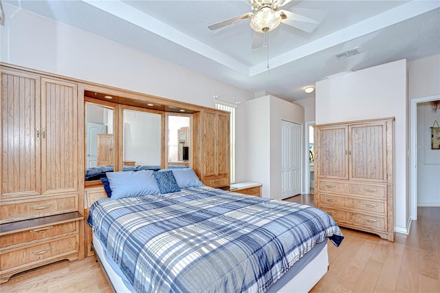 2226 N Creek Ct, Sun City Center, FL 33573 - bedroom with light wood-style floors, a closet, a raised ceiling, and ceiling fan