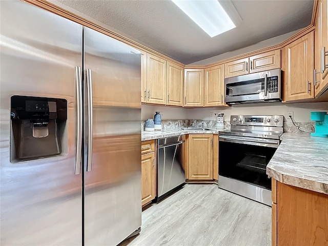 1207 Pine Ridge Cir W Unit H2, Tarpon Springs, FL 34688 - kitchen featuring stainless steel appliances, light wood-style floors, light countertops, and light brown cabinets