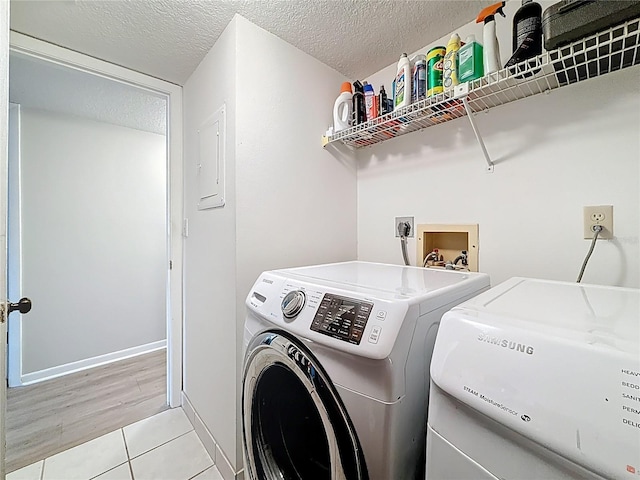 1207 Pine Ridge Cir W Unit H2, Tarpon Springs, FL 34688 - laundry area with separate washer and dryer, electric panel, a textured ceiling, and light tile patterned floors