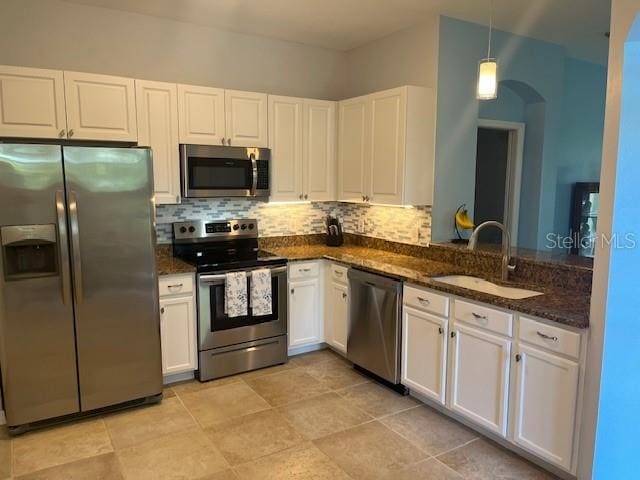 3665 Country Pointe Pl, Palm Harbor, FL 34684 - kitchen with stainless steel appliances, backsplash, white cabinetry, and pendant lighting
