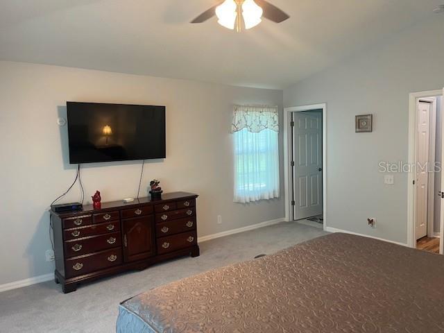 3665 Country Pointe Pl, Palm Harbor, FL 34684 - carpeted bedroom featuring vaulted ceiling and ceiling fan