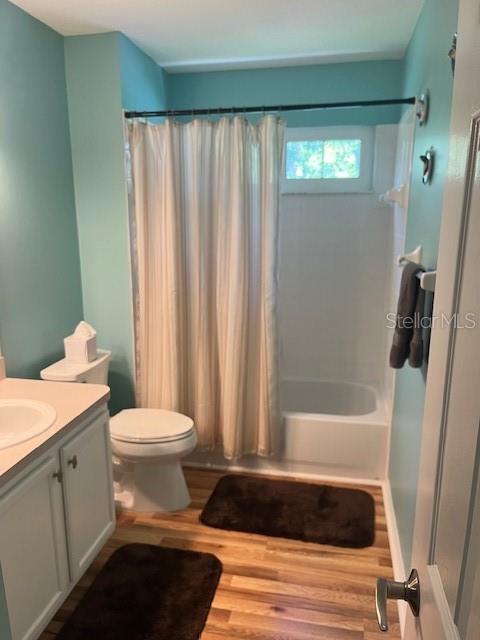 3665 Country Pointe Pl, Palm Harbor, FL 34684 - full bath with vanity, shower / bath combination with curtain, and wood finished floors