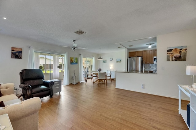 123 Glendower Cir Unit 123, Sun City Center, FL 33573 - living area featuring light wood-type flooring, a textured ceiling, a ceiling fan, and recessed lighting