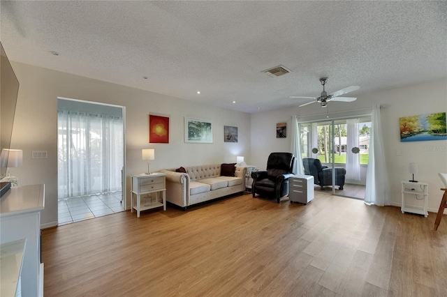 123 Glendower Cir Unit 123, Sun City Center, FL 33573 - living room featuring a textured ceiling, light wood-style flooring, and ceiling fan