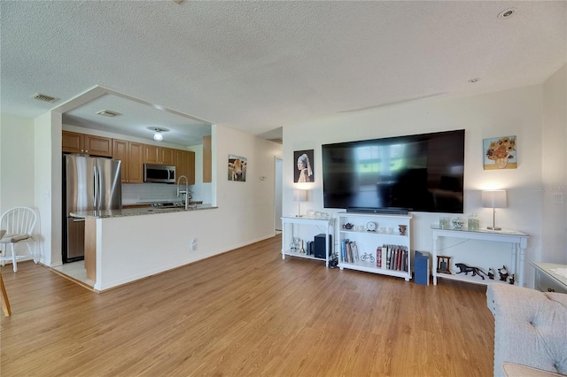 123 Glendower Cir Unit 123, Sun City Center, FL 33573 - living area featuring light wood-style floors and a textured ceiling