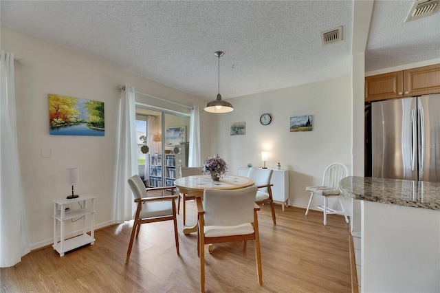 123 Glendower Cir Unit 123, Sun City Center, FL 33573 - dining area featuring a textured ceiling and light wood-style flooring