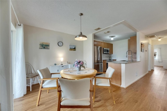 123 Glendower Cir Unit 123, Sun City Center, FL 33573 - dining space with light wood-type flooring and a textured ceiling