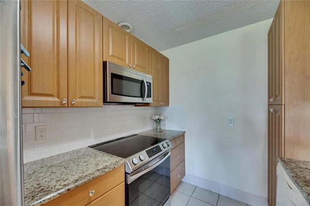 123 Glendower Cir Unit 123, Sun City Center, FL 33573 - kitchen with stainless steel appliances, light tile patterned floors, backsplash, light stone countertops, and a textured ceiling