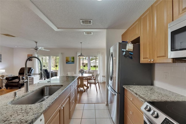 123 Glendower Cir Unit 123, Sun City Center, FL 33573 - kitchen with a textured ceiling, appliances with stainless steel finishes, a ceiling fan, backsplash, and open floor plan