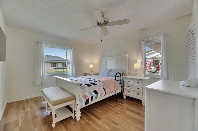123 Glendower Cir Unit 123, Sun City Center, FL 33573 - bedroom featuring light wood-style floors, a textured ceiling, and a ceiling fan