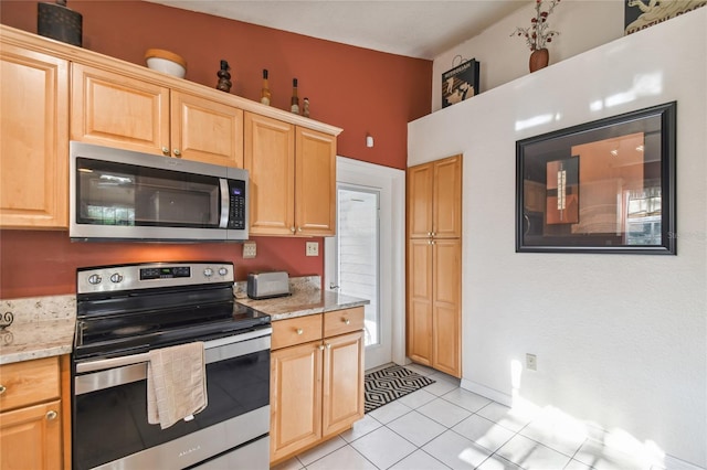5908 Mohr Rd, Tampa, FL 33615 - kitchen featuring appliances with stainless steel finishes, light tile patterned floors, light brown cabinets, and light stone counters