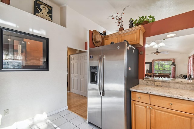 5908 Mohr Rd, Tampa, FL 33615 - kitchen with stainless steel fridge with ice dispenser, light tile patterned flooring, vaulted ceiling, ceiling fan, and light stone counters