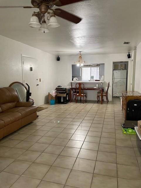 8636 Tahoe Ct Unit 13, Tampa, FL 33614 - living area featuring light tile patterned floors, ceiling fan, and a chandelier