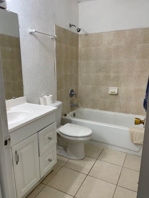 8636 Tahoe Ct Unit 13, Tampa, FL 33614 - bathroom featuring tile patterned floors, shower / bath combination, a textured wall, and vanity