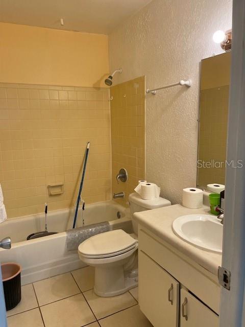 8636 Tahoe Ct Unit 13, Tampa, FL 33614 - bathroom featuring a textured wall, shower / bathtub combination, tile patterned floors, and vanity