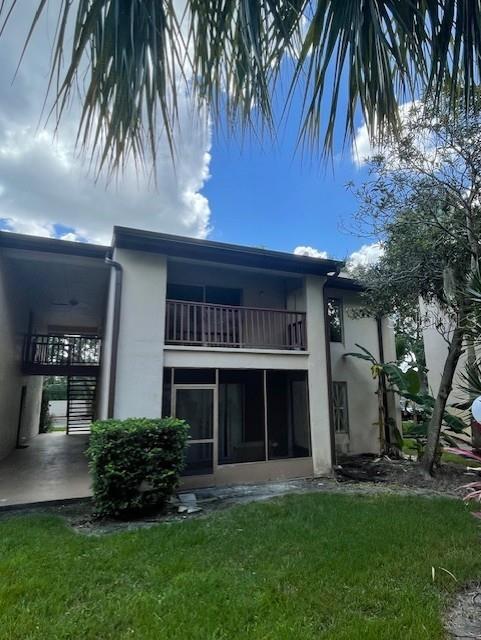 8636 Tahoe Ct Unit 13, Tampa, FL 33614 - rear view of house with a balcony, stucco siding, and a yard
