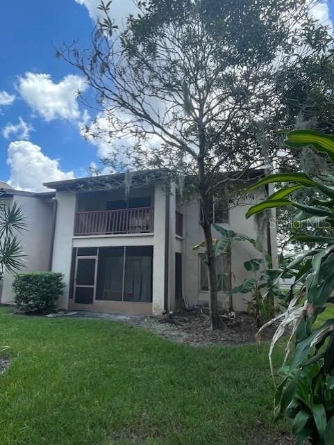 8636 Tahoe Ct Unit 13, Tampa, FL 33614 - rear view of house with a balcony, stucco siding, and a lawn