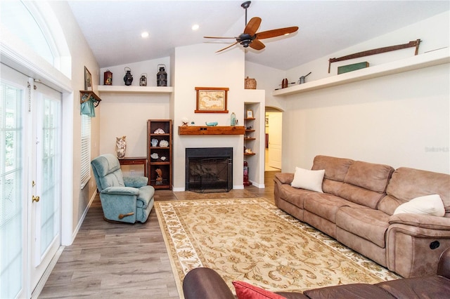 11945 Darwin Ave, New Port Richey, FL 34654 - living room featuring vaulted ceiling, a fireplace, a ceiling fan, recessed lighting, and light wood-style floors