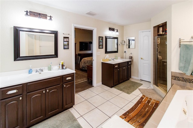 11945 Darwin Ave, New Port Richey, FL 34654 - full bath with two vanities, a bath, ensuite bath, a stall shower, and tile patterned flooring