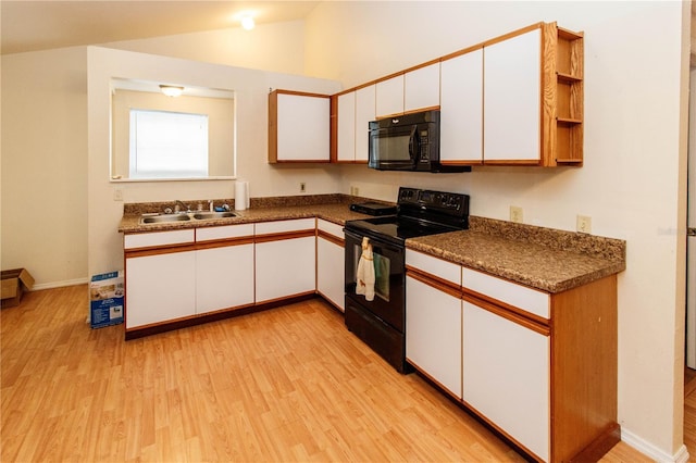 11945 Darwin Ave, New Port Richey, FL 34654 - kitchen with black appliances, white cabinetry, light wood-type flooring, open shelves, and vaulted ceiling