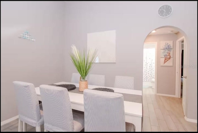 1004 Osage St, Clearwater, FL 33755 - dining area with arched walkways and light wood finished floors