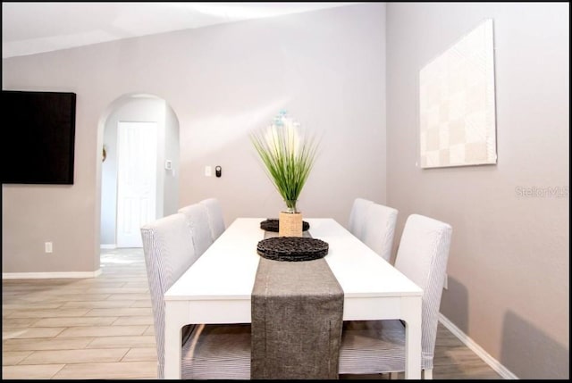 1004 Osage St, Clearwater, FL 33755 - dining area with arched walkways and light wood-type flooring