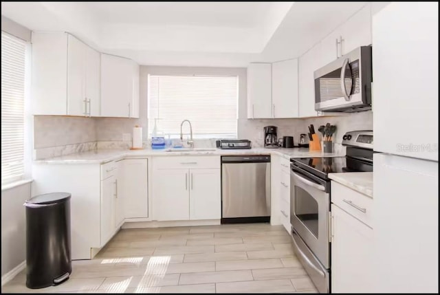 1004 Osage St, Clearwater, FL 33755 - kitchen featuring stainless steel appliances, light countertops, white cabinetry, and decorative backsplash