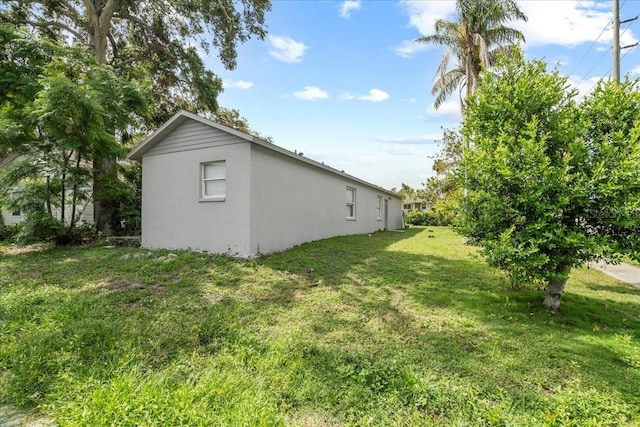 1004 Osage St, Clearwater, FL 33755 - view of side of property featuring stucco siding and a yard