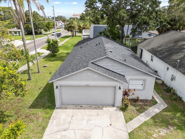 1004 Osage St, Clearwater, FL 33755 - view of front of home featuring a shingled roof, an attached garage, a front yard, and driveway