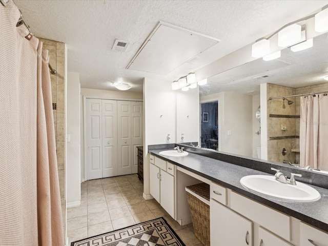 2010 E Palm Ave Unit 14303, Tampa, FL 33605 - full bath featuring tile patterned flooring, double vanity, a tile shower, and a textured ceiling