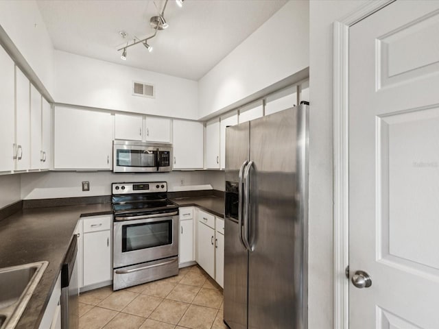 2010 E Palm Ave Unit 14303, Tampa, FL 33605 - kitchen featuring stainless steel appliances, dark countertops, white cabinets, and light tile patterned flooring