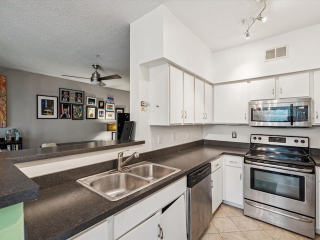 2010 E Palm Ave Unit 14303, Tampa, FL 33605 - kitchen featuring appliances with stainless steel finishes, white cabinets, dark countertops, light tile patterned floors, and open floor plan